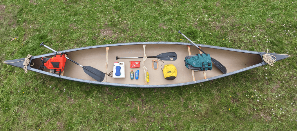 a canoe packed with extra paddles, approved life jackets, safety ropes, and other safety gear