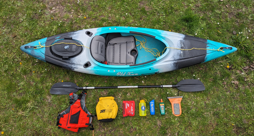 a kayak packed with paddles, approved life jackets, safety ropes, and other safety gear