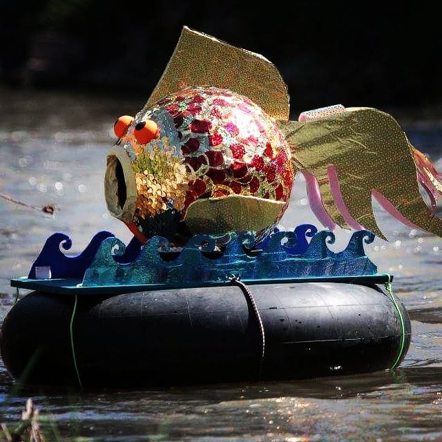 Goldfish sculpture on inner tube floating down Onondaga Creek, creekfloat.org